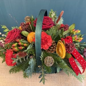 Festive Basket filled with seasonal fresh flowers, with dried fruit and cones with festive velvet ribbon.